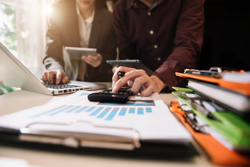 Scène de travail en bureau avec deux professionnels analysant des données financières