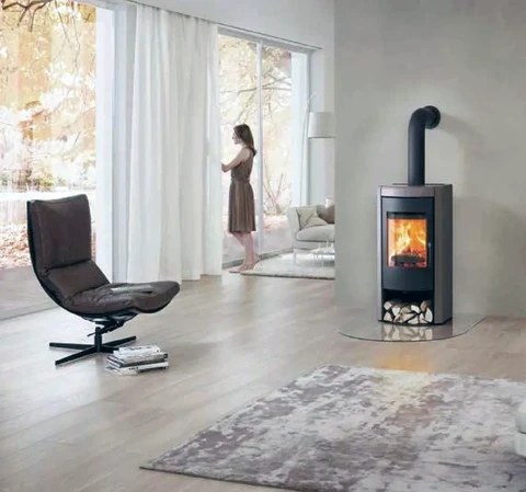 Intérieur moderne avec femme debout près de baies vitrées donnant sur jardin automnal